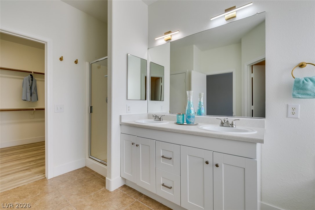 10959 Pumpkin Ridge Avenue Las Vegas, NV 89135 - Photo 28 of 51 A well-appointed primary bathroom featuring a double vanity and a convenient walk-in closet.