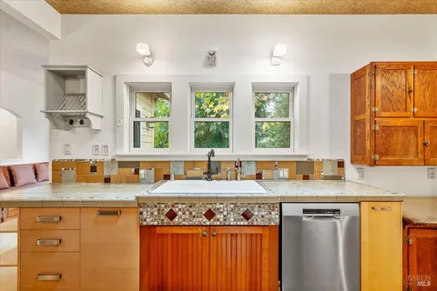 a kitchen with granite countertop a sink stove and cabinets