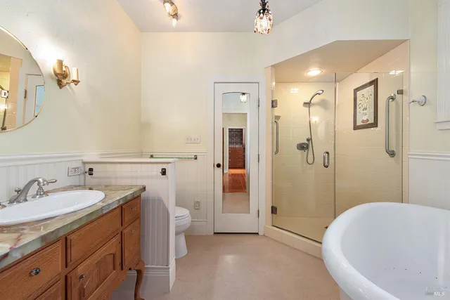 a spacious bathroom with a tub sink and mirror