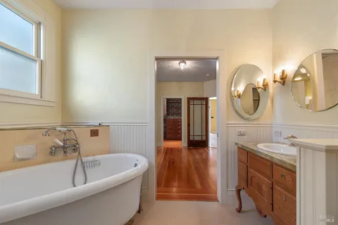 a bathroom with a tub sink and mirror