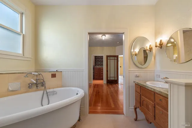 a bathroom with a tub sink and mirror
