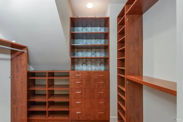 a view of walk in closet with empty racks