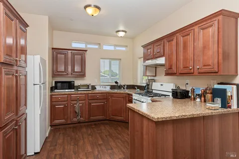 a kitchen with stainless steel appliances granite countertop a stove a sink dishwasher and a refrigerator