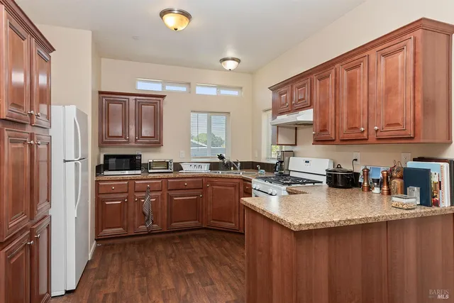 a kitchen with stainless steel appliances granite countertop a stove a sink dishwasher and a refrigerator
