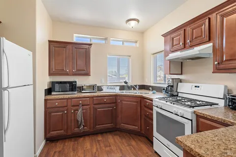 a kitchen with stainless steel appliances granite countertop a stove a sink dishwasher and a refrigerator