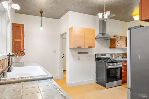 a kitchen with stainless steel appliances granite countertop a sink a stove and a refrigerator