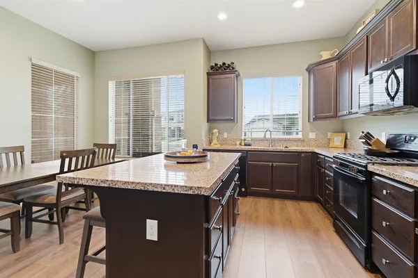 a kitchen with a stove a sink a dining table and chairs
