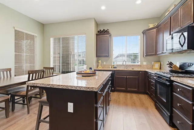 a kitchen with a stove a sink a dining table and chairs