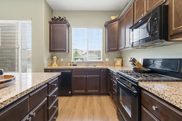 a kitchen with stainless steel appliances granite countertop a stove a sink and a microwave