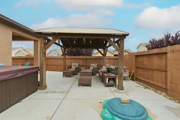 a backyard of a house with dishwasher fire pit and wooden fence