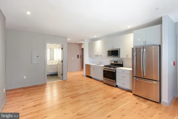 a large kitchen with cabinets and stainless steel appliances