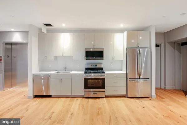 a kitchen with stainless steel appliances a refrigerator stove and microwave
