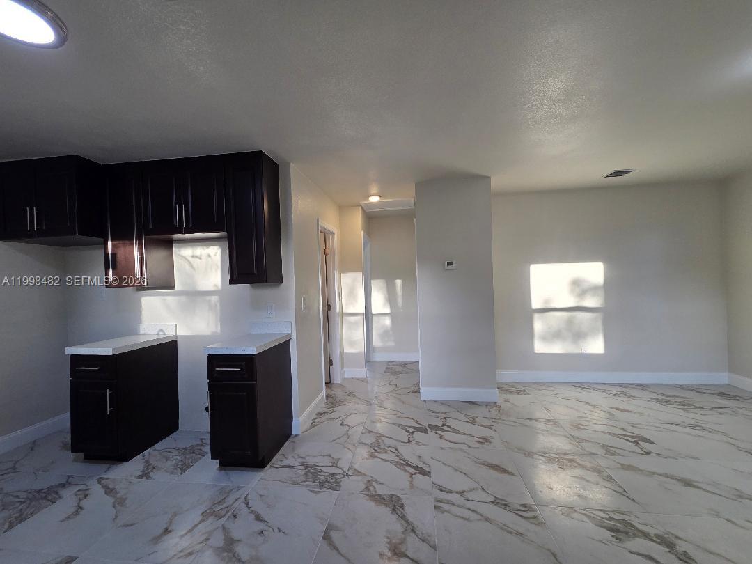 295 Northwest 48th Street Miami, FL 33127 - Photo 3 of 12 a view of kitchen with stainless steel appliances granite countertop cabinets and outdoor space