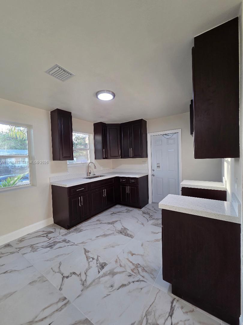 295 Northwest 48th Street Miami, FL 33127 - Photo 4 of 12 a large bathroom with a double vanity sink and mirror