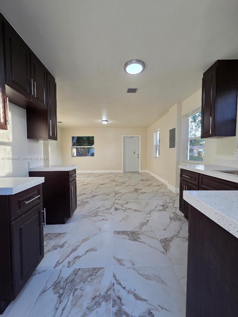295 Northwest 48th Street Miami, FL 33127 - Photo 6 of 12 a kitchen with a sink a stove and cabinets