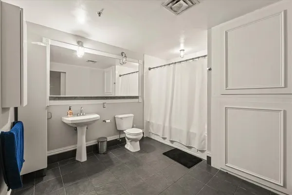 a bathroom with a sink a toilet and a mirror