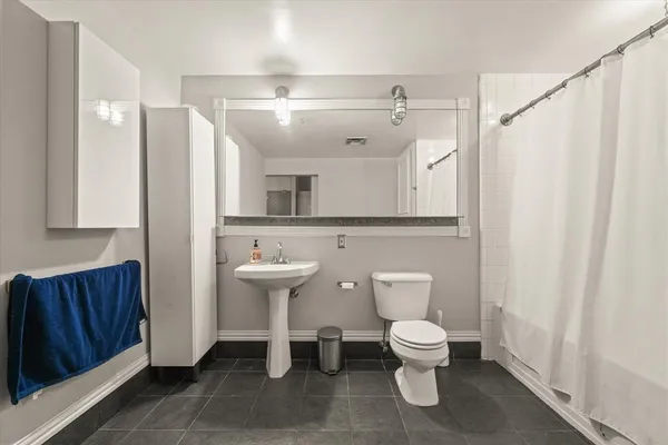 a bathroom with a toilet a sink and a mirror