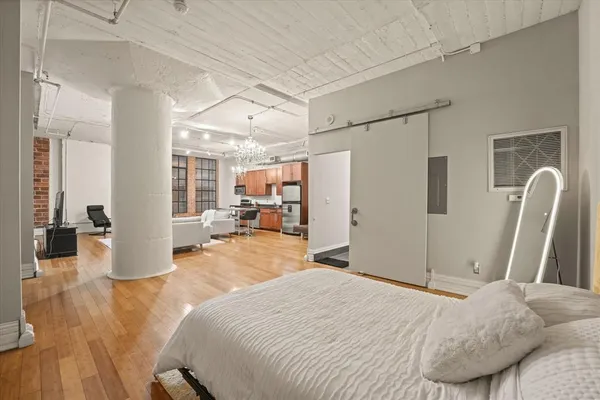 a bedroom with a bed and wooden floor