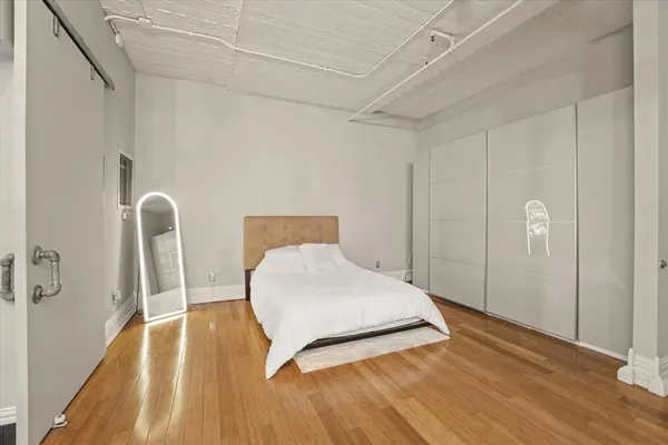 a bedroom with a bed and wooden floor