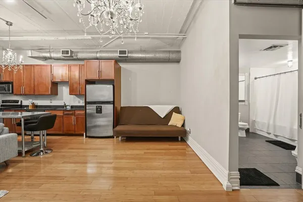 a living room with stainless steel appliances kitchen island granite countertop a refrigerator and a stove