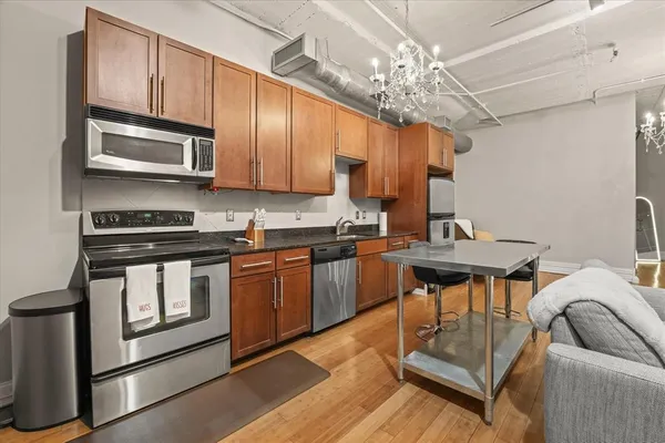a kitchen with stainless steel appliances granite countertop a stove a sink dishwasher and microwave oven with cabinets
