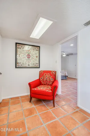 a living room with furniture a red rug and a wall painting