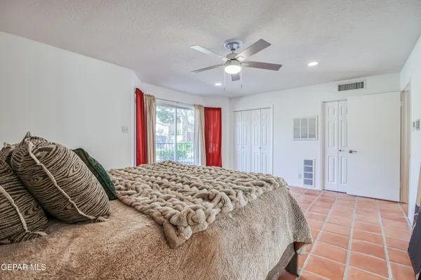 a bedroom with a large bed and a chandelier