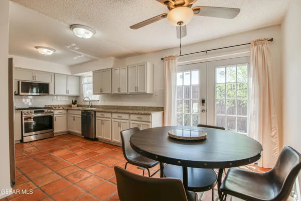 a kitchen with a sink dishwasher a stove a kitchen island with a dining table and chairs