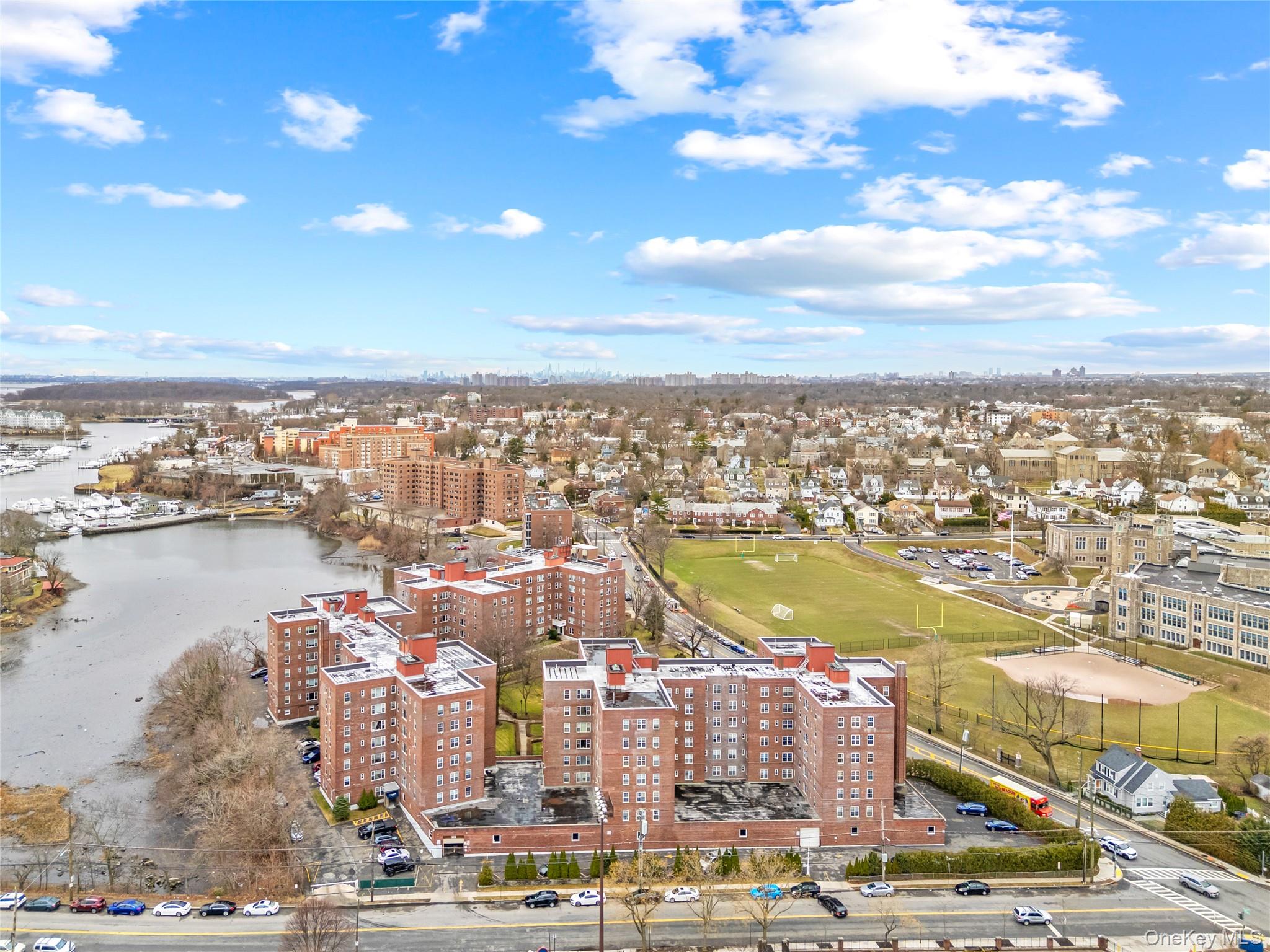 230 Pelham Road, Unit 4L New Rochelle, NY 10805 - Photo 8 of 30 Aerial view showcasing the building’s prime waterfront setting with scenic views of the New York City skyline in the background.