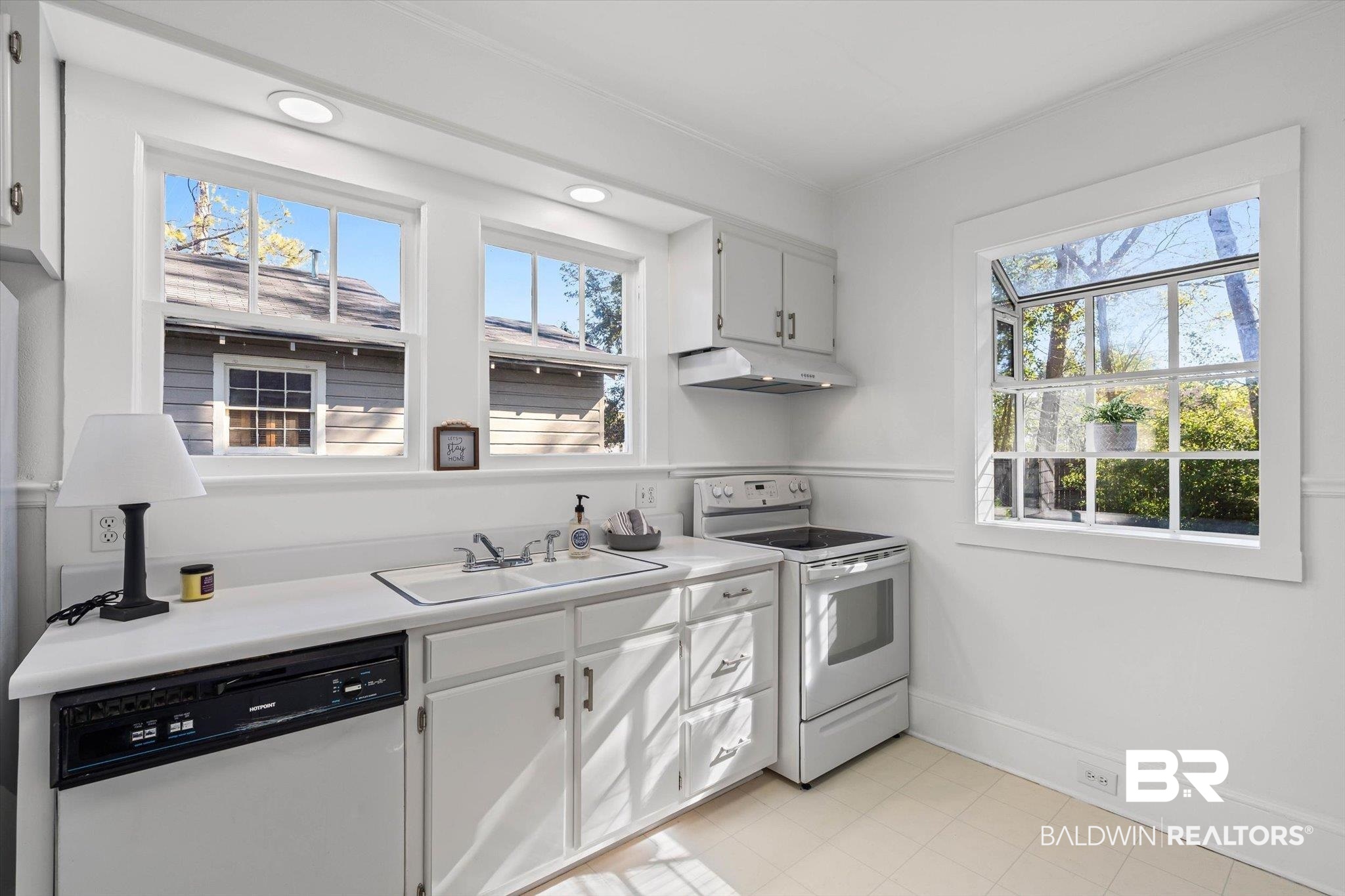 2153 Old Government Street Mobile, AL 36606 - Photo 7 of 23 Kitchen featuring white electric range oven, dishwasher, light countertops, under cabinet range hood, and white cabinetry