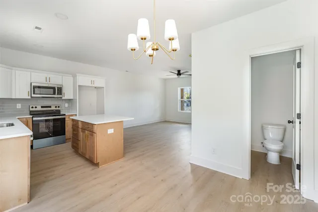 a kitchen with a refrigerator and a stove top oven
