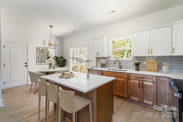 a kitchen with a dining table chairs and white cabinets