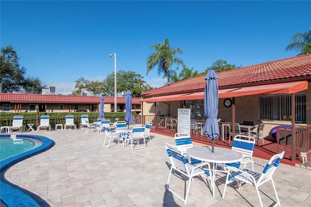 a view of a patio with a table and chairs under an umbrella