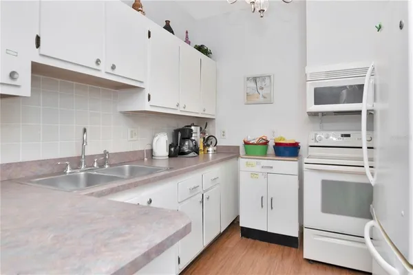 a kitchen with white cabinets and white appliances