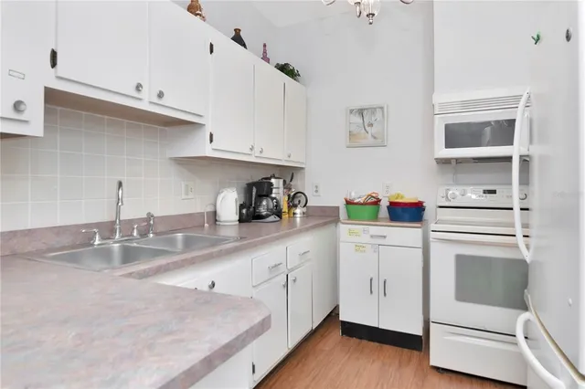 a kitchen with white cabinets and white appliances