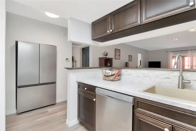 a kitchen with stainless steel appliances granite countertop a refrigerator and a sink