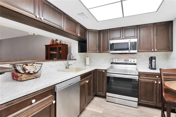 a kitchen with stainless steel appliances a stove a sink and cabinets