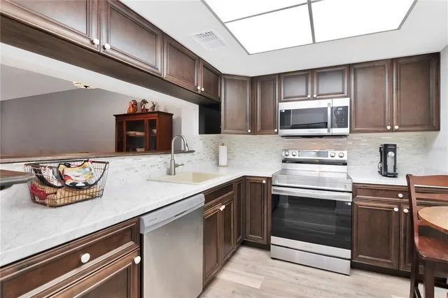 a kitchen with stainless steel appliances a stove a sink and cabinets