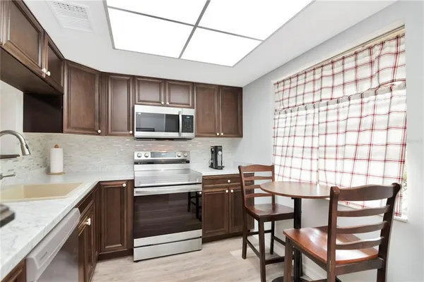 a kitchen with a table chairs microwave and cabinets