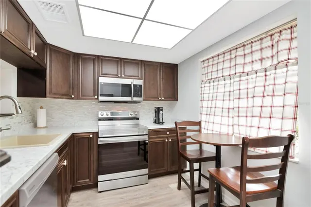 a kitchen with a table chairs microwave and cabinets