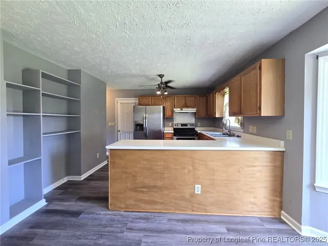 a view of kitchen with stainless steel appliances granite countertop sink and wooden floor