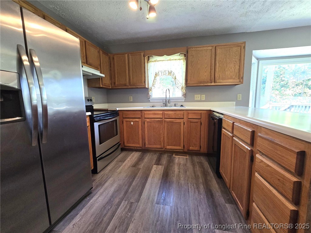 7132 Dayspring Drive Fayetteville, NC 28314 - Photo 16 of 44 a kitchen with stainless steel appliances granite countertop a refrigerator a sink dishwasher a stove and white countertops with wooden floor