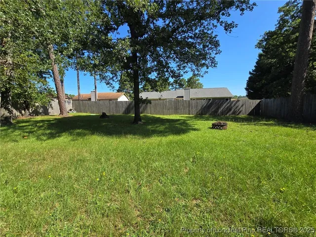 a view of yard with green space and trees