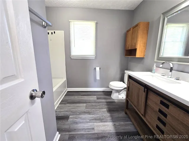 a bathroom with a double vanity sink a toilet and a mirror
