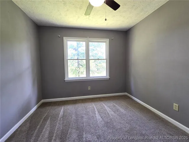 an empty room with fan and windows