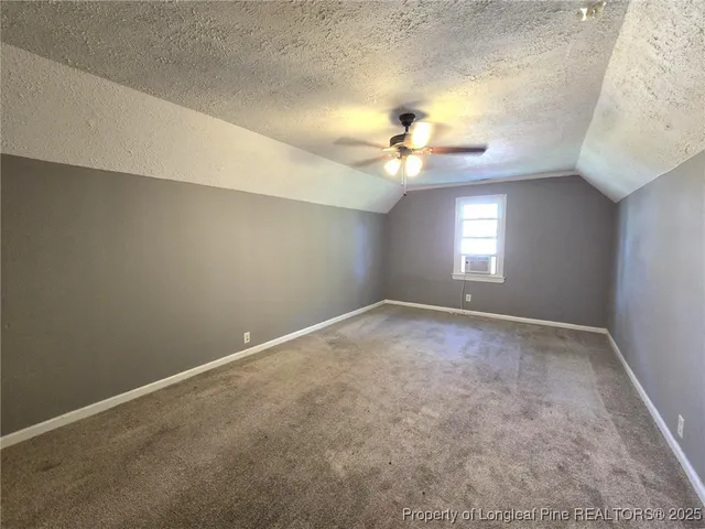 a view of an empty room with a chandelier fan