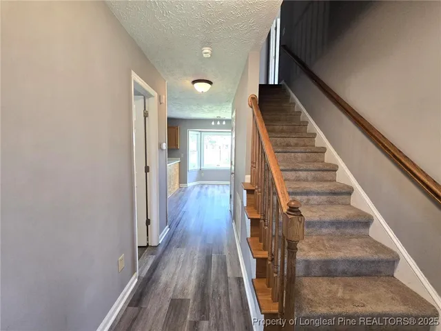 a view of entryway and gallery with wooden floor