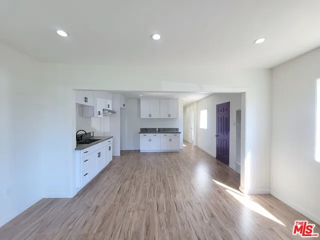 a kitchen with granite countertop a stove a sink and a refrigerator