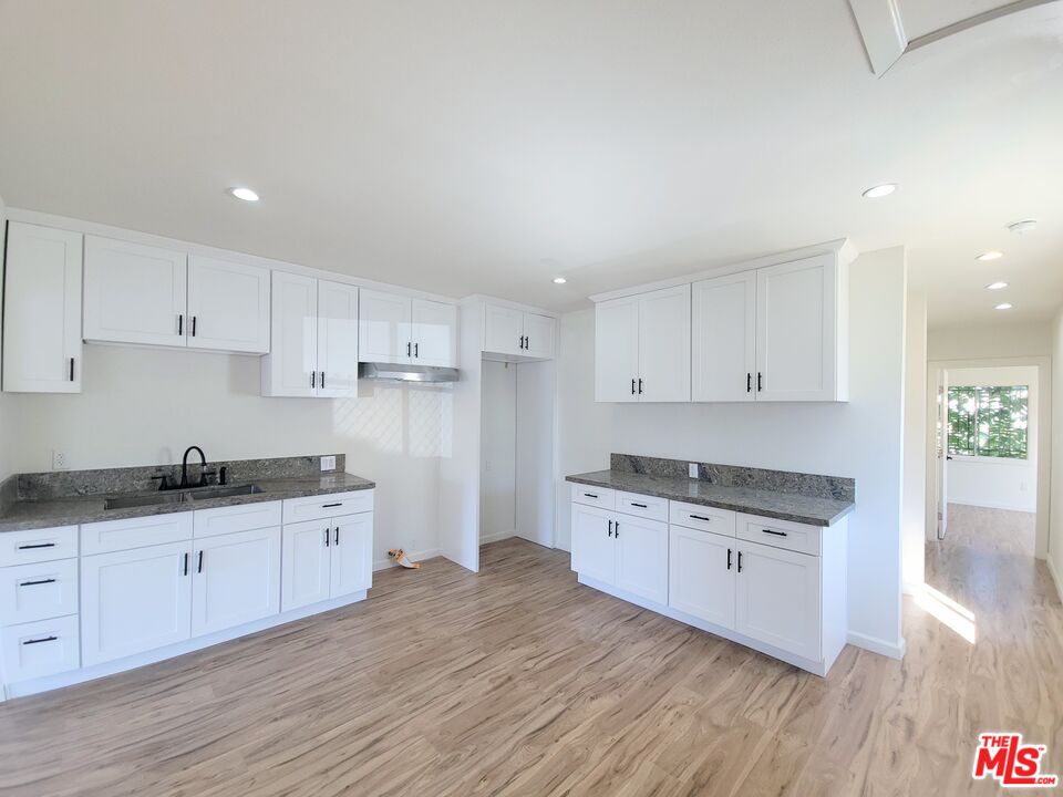 200 North Acacia Avenue Compton, CA 90220 - Photo 5 of 18 a kitchen with granite countertop a sink a stove and cabinets