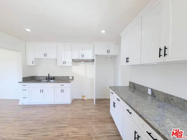 a kitchen with granite countertop white cabinets white stainless steel appliances and a granite counter tops